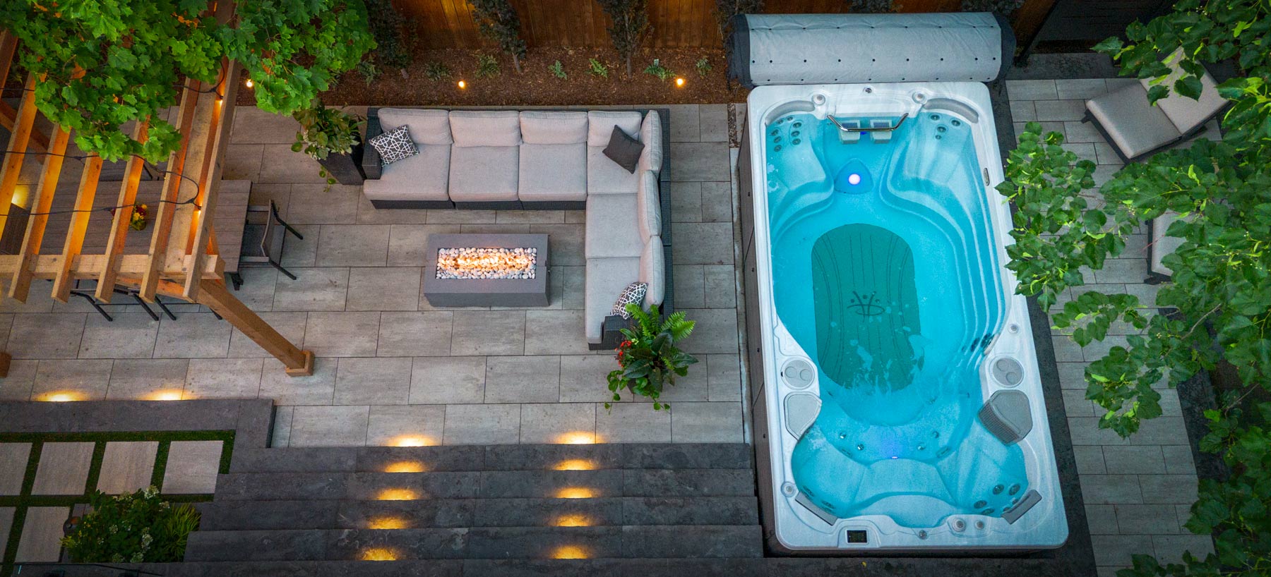 Bird’s-eye view of a finished outdoor living space — patio, lighting, and spa integration.